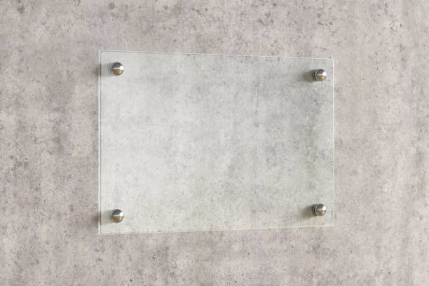 istock Blank transparent glass sign plate on the wall. 1209446756
