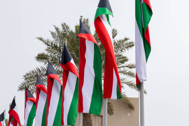 istock Multiple Kuwait national flags flying during the day at a event in Qatar 1209446799