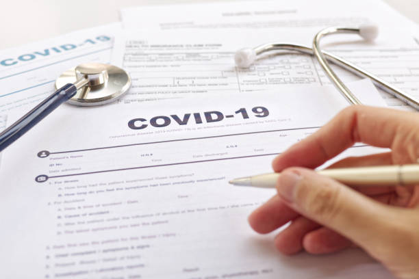 COVID-19 Health insurance concept. Blurring of hand holding pen and Stethoscope on health form. Focus on " COVID-19 " COVID-19 Health insurance concept. Blurring of hand holding pen and Stethoscope on health form. Focus on " COVID-19 " claim form photos stock pictures, royalty-free photos & images