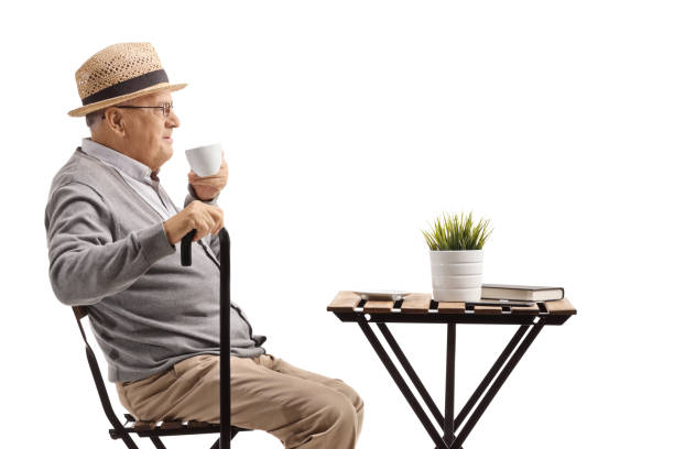 istock Elderly man with cane sitting and drinking coffee 1209448583