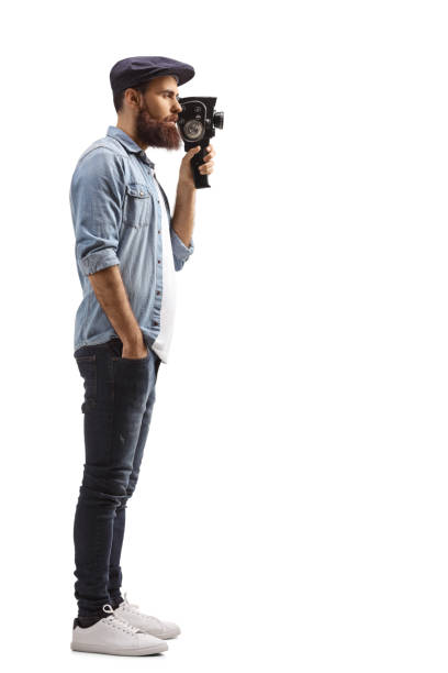 istock Bearded guy recording with a vintage camera 1209449346