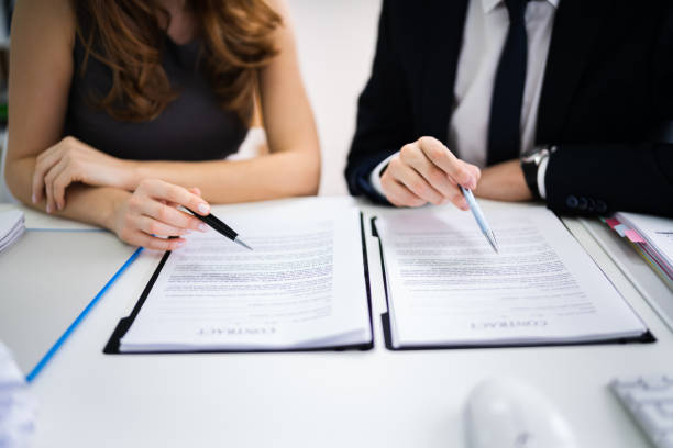 istock Two Businesspeople Working On Contract Paper 1209450025