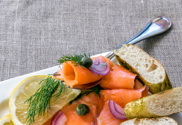 istock Close-up  top view on thinly slices of smoked salmon on fish fork 1209454075