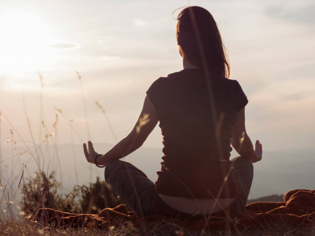istock Young woman meditating outdoors 1209454435