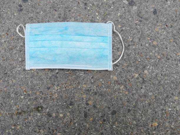 istock Disposable surgical mask thrown on the ground 1209455594