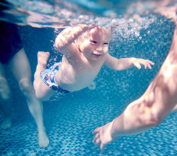 istock Adorable little boy swimming under water. 1209456053