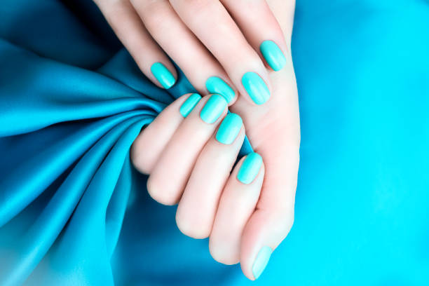 istock Female hands with manicure mint turquoise on a turquoise background 1209456171