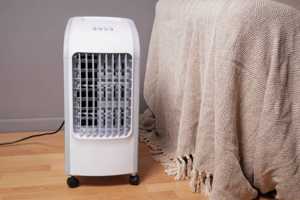 portable air cooler and humidifier in living room portable air cooler and humidifier on casters in domestic living room to improve indoor clmate portability stock pictures, royalty-free photos & images