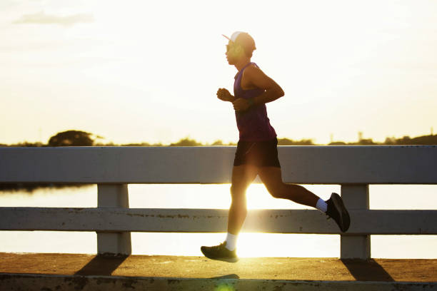 istock Attractive fit man running fast along bridge at sunset light 1209457194