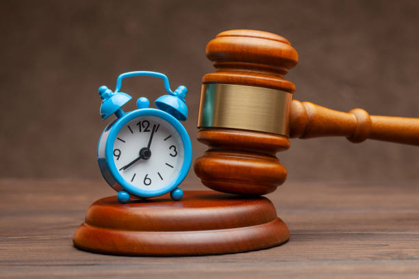 istock Alarm clock and hammer judge gavel on brown background 1209457273