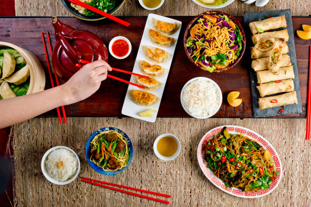 istock Chinese restaurant Chinese New Years celebration dinner meal with multiple courses and dishes served at the table. Lo Mein. Noodles. Beef Dish. Rice. Classic family style meal. 1209458564
