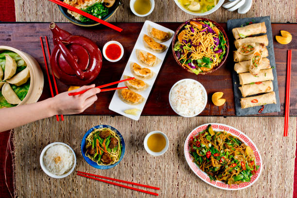 istock Chinese restaurant Chinese New Years celebration dinner meal with multiple courses and dishes served at the table. Lo Mein. Noodles. Beef Dish. Rice. Classic family style meal. 1209458584