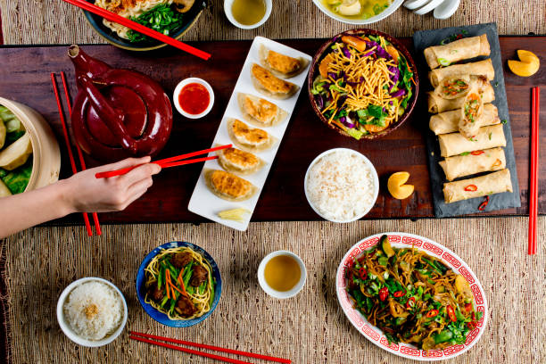 istock Chinese restaurant Chinese New Years celebration dinner meal with multiple courses and dishes served at the table. Lo Mein. Noodles. Beef Dish. Rice. Classic family style meal. 1209458613