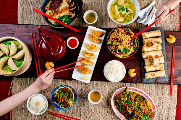istock Chinese restaurant Chinese New Years celebration dinner meal with multiple courses and dishes served at the table. Lo Mein. Noodles. Beef Dish. Rice. Classic family style meal. 1209458789