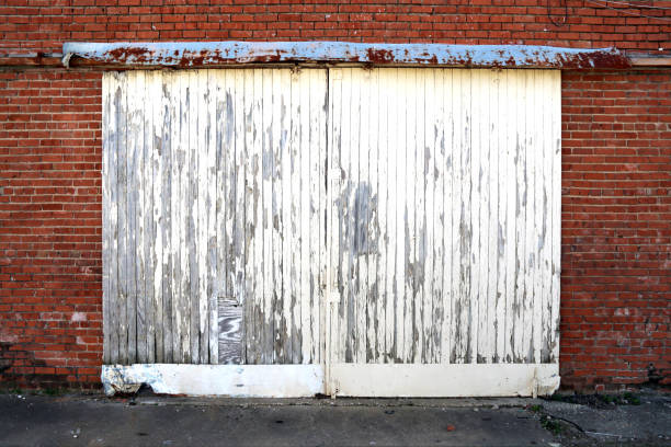istock white painted peeling warehouse shipping double doors 1209459926