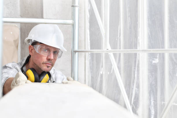 istock man work, professional construction worker  with scaffolding, safety hard hat, hearing protection headphones, gloves and protective glasses. on interior building site background 1209460983