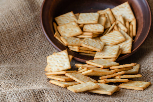 istock Pile of salted crackers on burlap. 1209461101
