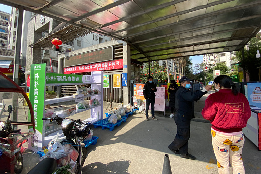 Fuzhou, Fujian, China. On February 19, 2020, the property manager took the temperature of people entering the residential area. Due to the outbreak, residents were forbidden from leaving residential areas.