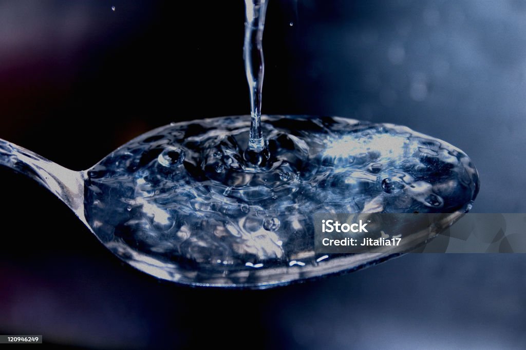 La tensione superficiale di acqua-cucchiaio - Foto stock royalty-free di Cucchiaio