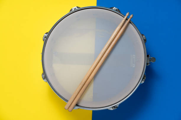 istock Drum stick and drum on yellow and blue table background, top view, music concept 1209466781