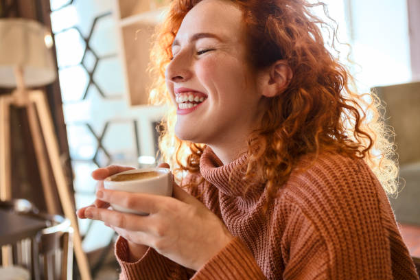 istock Young redhead woman drinking coffee smiling 1209472702