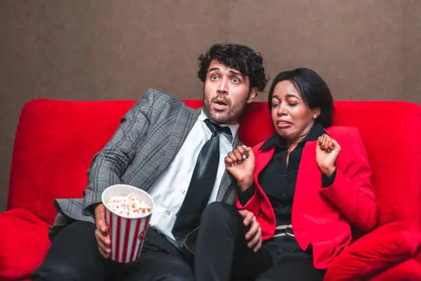 Scary and fear man woman couple with popcorn watch horror movie in cinema or theater