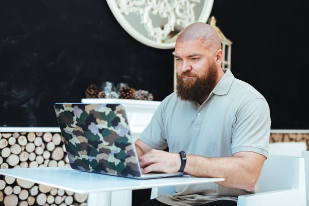 istock Young bearded hipster man using laptop, working at home, smart working (remote working) concept 1209474611