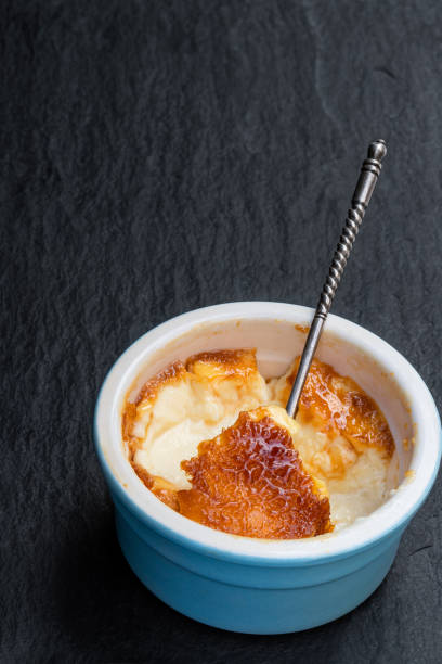 검은 돌 배경에 푸른 도자기 냄비에 크림 브릴리 - custard creme brulee french cuisine crema catalana 뉴스 사진 이미지