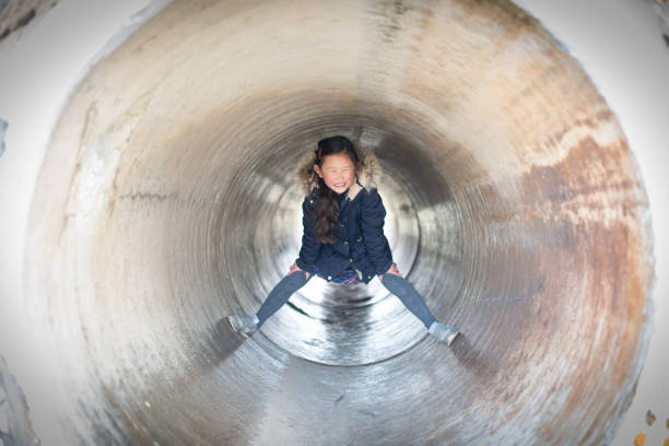 istock Girl playing in the park tunnel 1209478336