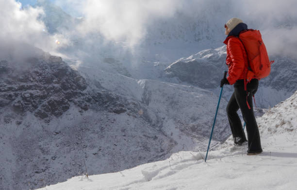 istock Female mountaineer ascends snowslope, in mountains 1209479281
