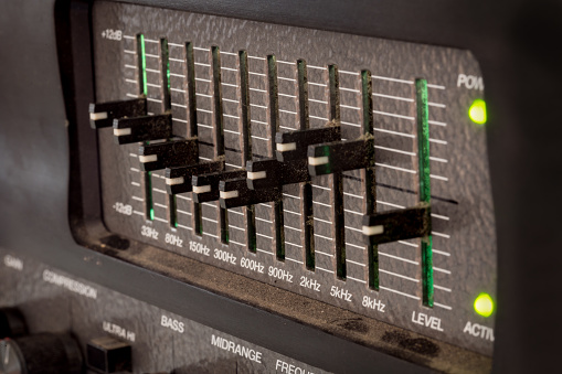 Old black controls of an audio equalizer from a guitar amplifier