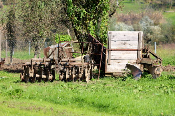 istock Various abandoned vintage retro rustic old dilapidated agricultural equipment with broken wooden tractor trailer left in backyard 1209481751