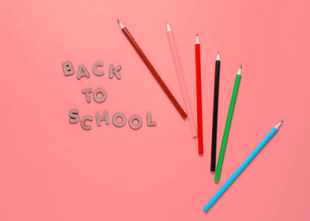 istock School time concept. Multicolored pencils on pink background with the text back to school. Top view 1209483902