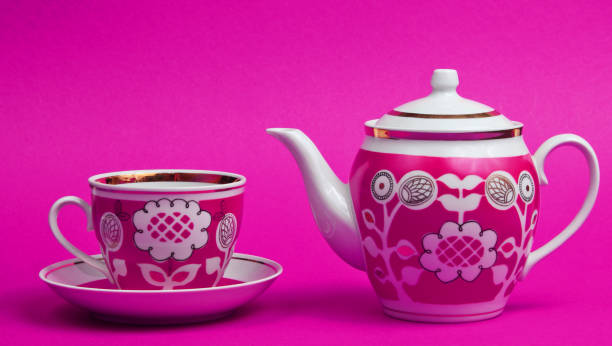 istock Retro ceramic cup and teapot on pink background. Top view 1209484102