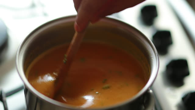 Stirring healthy orange vegetable soup