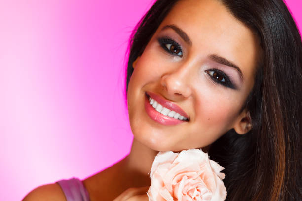 Beautiful young woman studio portrait with a purple background.
