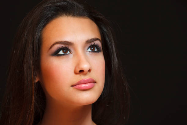 Beautiful young woman studio portrait with a black background.