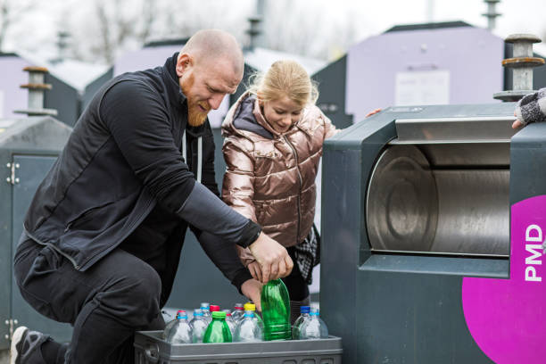 istock Father and daughter recycling plastic bottles 1209487288