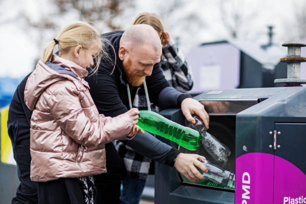 Father and daughters recycling plastic bottles