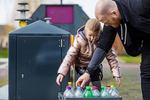 istock Father and daughter recycling plastic 1209487959
