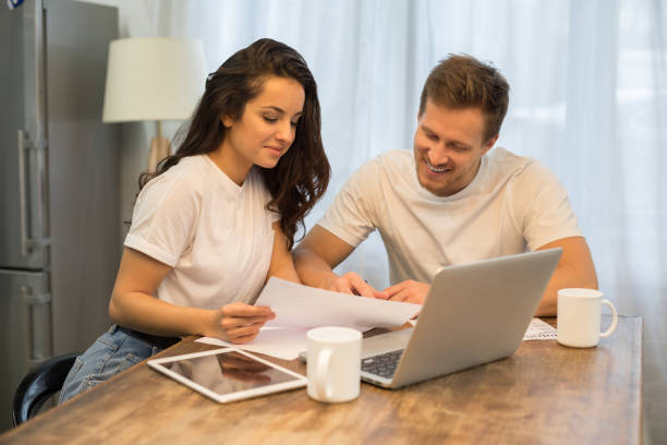 istock Joyful young couple working with laptop at the table 1209488088