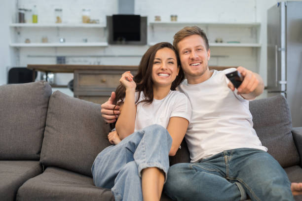istock Happy boyfriend and girlfriend sitting on sofa at home 1209488824