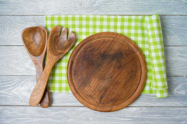istock Round pizza board with green checked tablecloth on rustic wooden table 1209490439