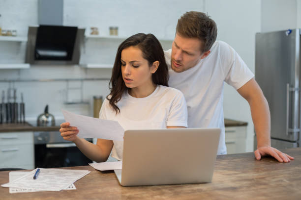 istock Young couple looking on documents together at home 1209491274