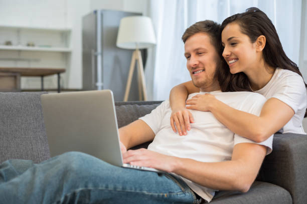 istock Smiling young couple looking at gadget screen at home 1209492397
