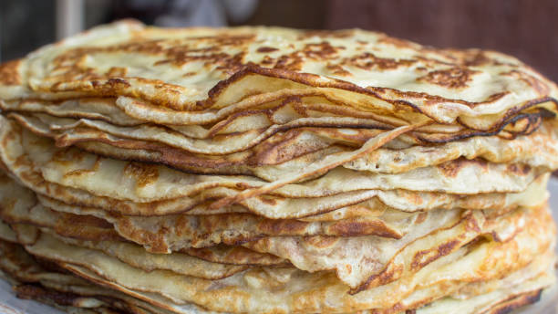 A stack of delicious pancakes on a plate Traditional Slavic holiday Maslenitsa. Thin pancakes. A lot of fragrant pancakes. Tasty treat. Homemade food. Dish on milk, kefir or whey. Holiday celebrations. Fry pancakes in a pan. crêpe pancake photos stock pictures, royalty-free photos & images