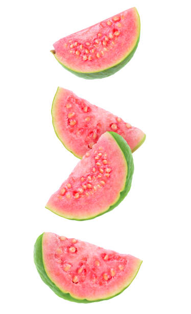 Falling guava slices Isolated guava slices. Four wedges of green pink fleshed guava fruits isolated on white background with clipping path guava photos stock pictures, royalty-free photos & images