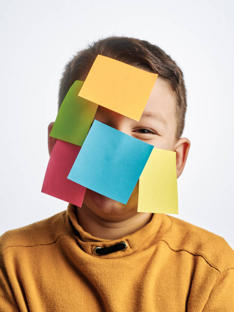 istock Cute child on white background. There is adhesive notes on his face. 1209500042
