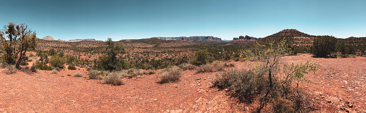A wide angle, panoramic photo of a sunny desert