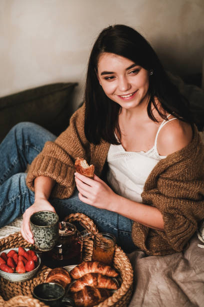 istock Young beautiful smiling brunette woman having breakfast in bed 1209501610